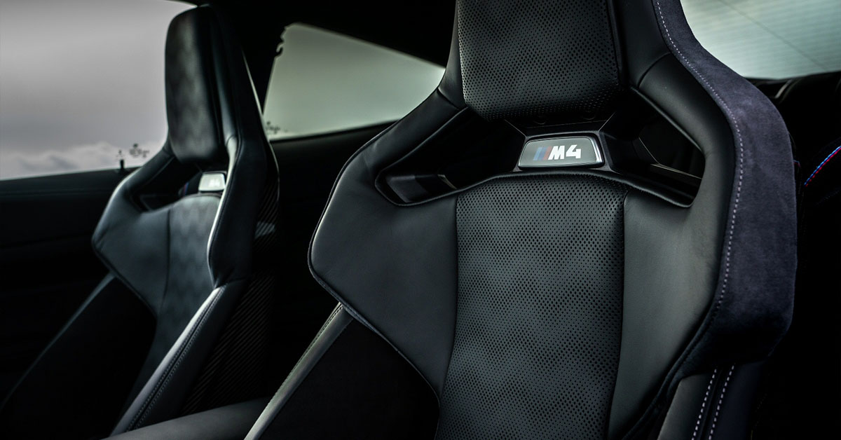 An image of a 2022 BMW M4 Coupe interior showing the M badge embossed seats
