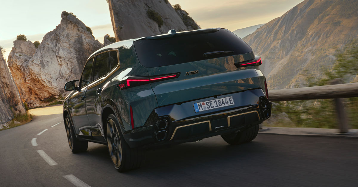 An image of the 2023 BMW XM Hybrid SUV in motion from the rear