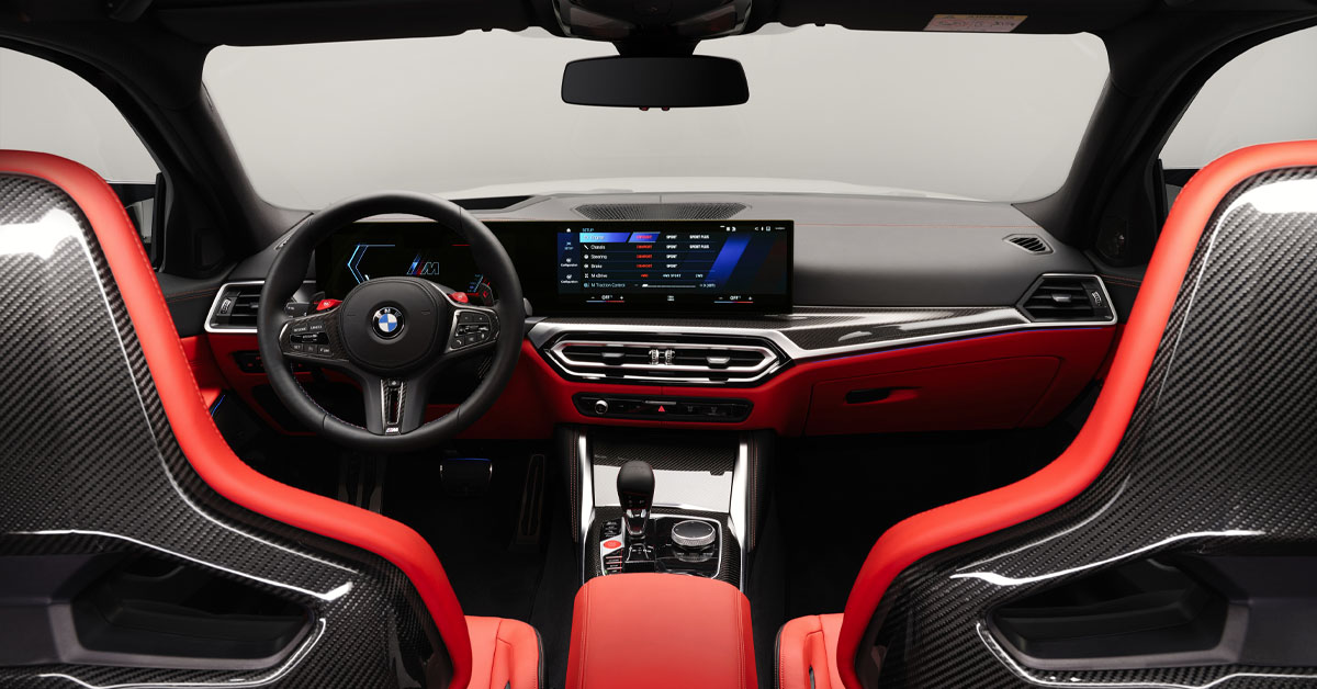 An image of the 2022 BMW M3 Competition Touring xDrive interior front dashboard section taken from the rear passenger seats point of view