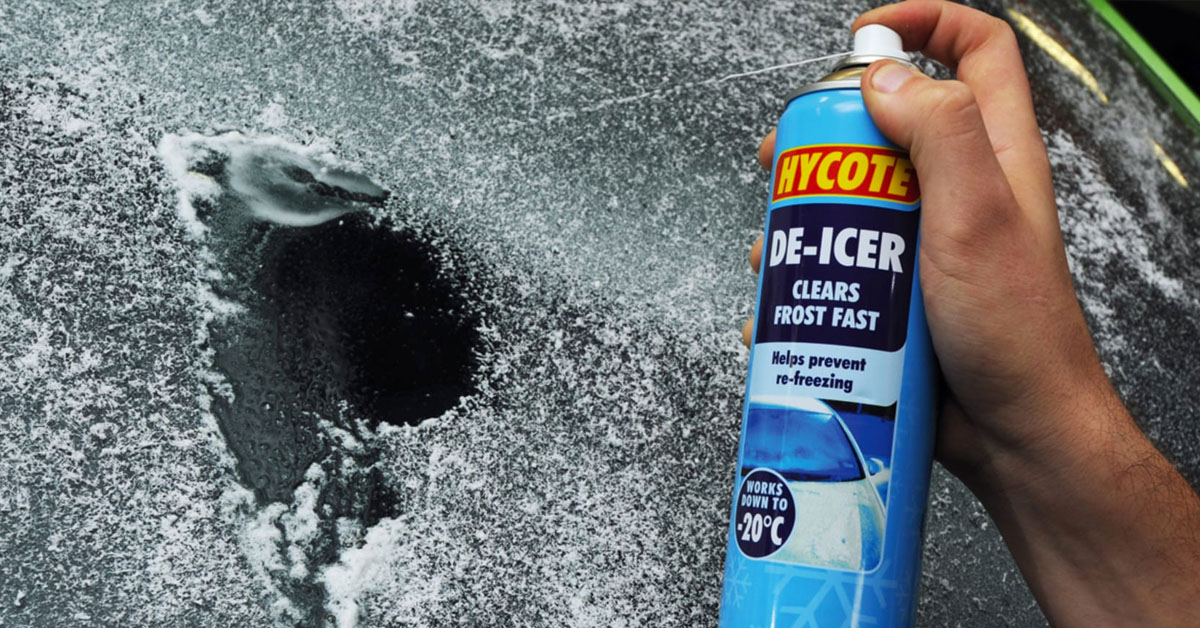 An image of a de-icer branded spray being used on a frozen car windshield