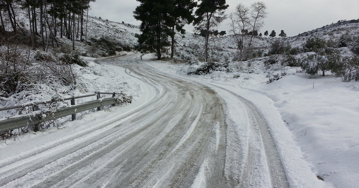 An image of an icy and snow filled road in the countryside